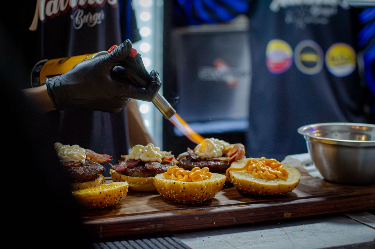 Crafting Captivating Headlines: Your awesome post title goes here Chef using torch on gourmet burgers in kitchen. Perfect for culinary art and food preparation concepts.